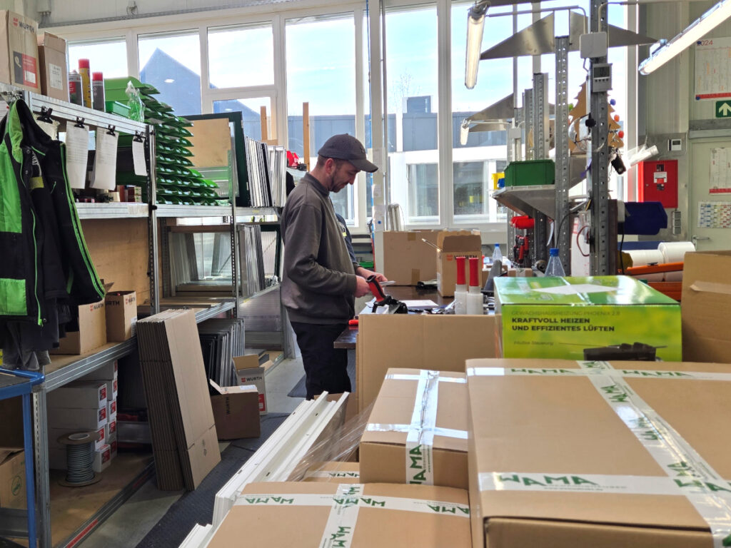 Ein WAMA-Mitarbeiter kommissioniert am Packplatz alle Packstücke einer Kundenbestellung anhand der Packliste.